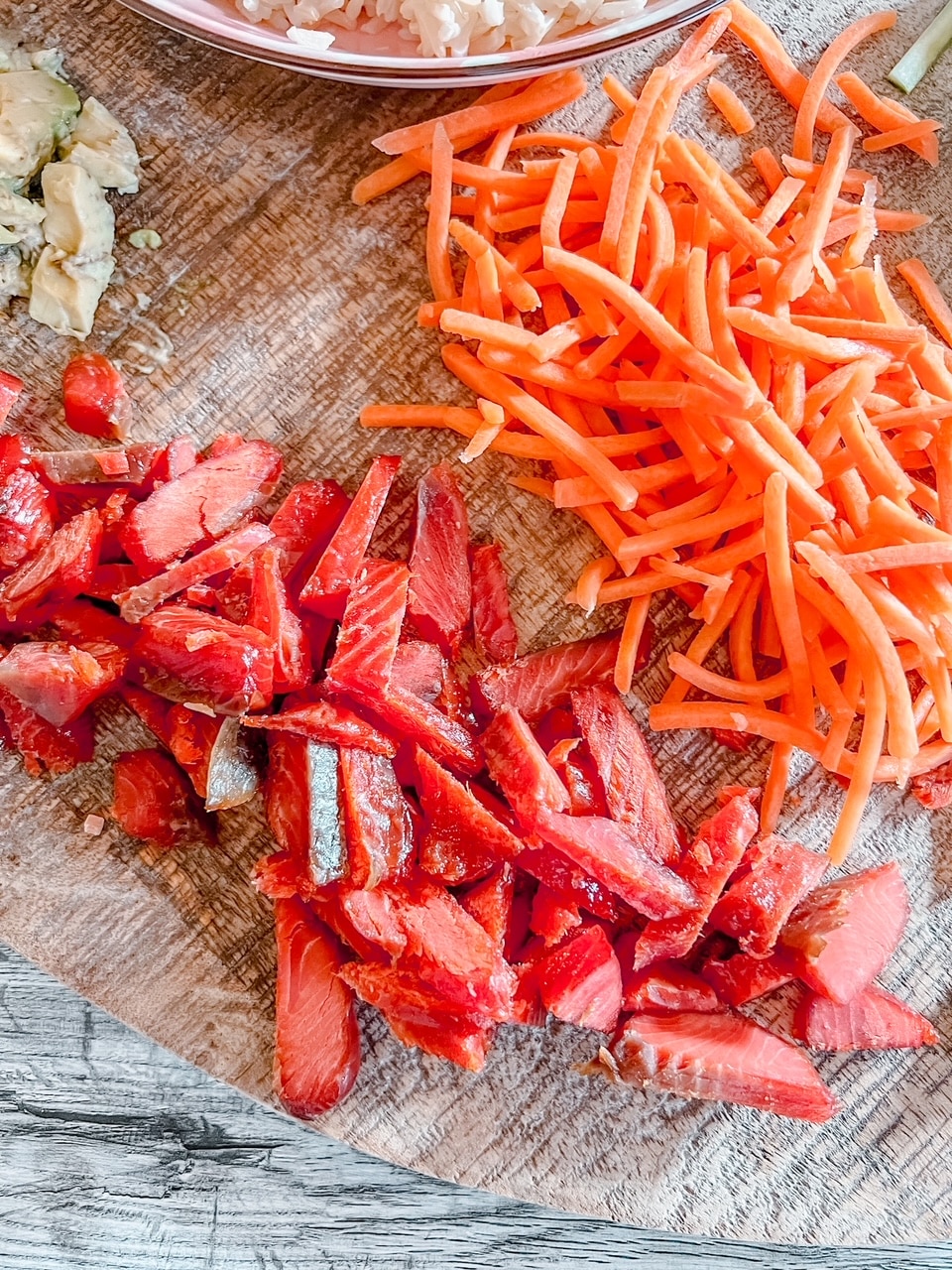 overhead view of smoked salmon, shredded carrots, and avocado