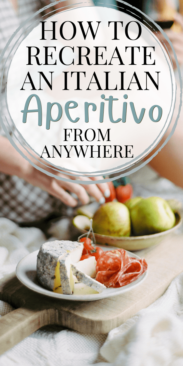A rustic platter featuring gourmet cheese, cured meats, cherry tomatoes, and fresh fruit, styled as part of an Italian aperitivo spread. The text overlay reads "How to Recreate an Italian Aperitivo From Anywhere."