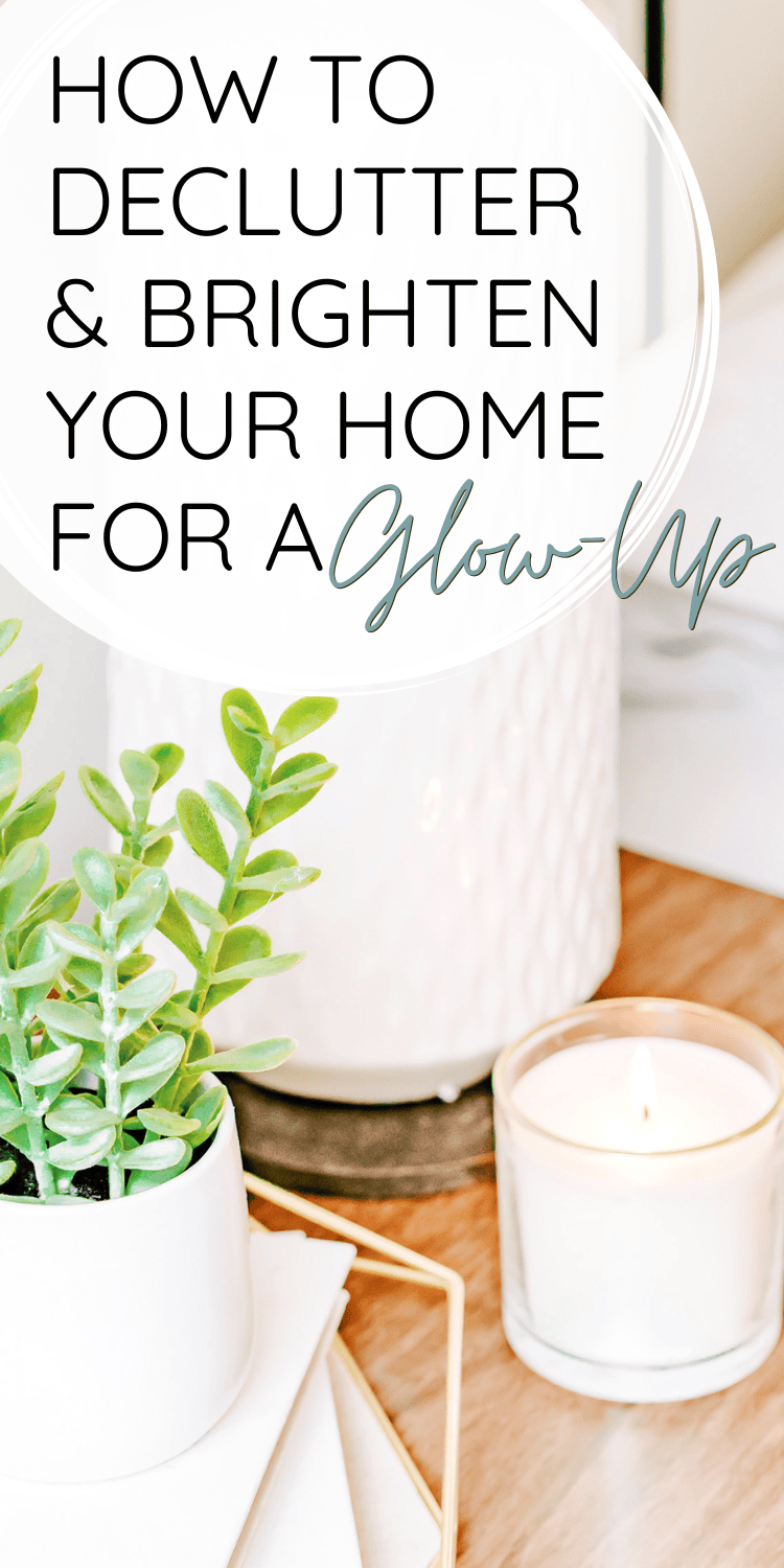 A Pinterest graphic with text overlay reading 'How to Declutter & Brighten Your Home for a Glow-Up.' The image shows a minimalistic setup with a lit candle, a small green potted plant, and a clean white vase on a wooden surface, evoking a fresh and cozy spring vibe.