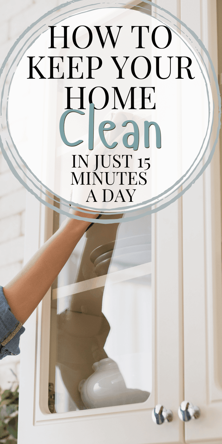 A person wipes down the glass door of a white cabinet with a soft cloth. Overlaid text in a stylish circular design reads, "How to Keep Your Home Clean in Just 15 Minutes a Day."