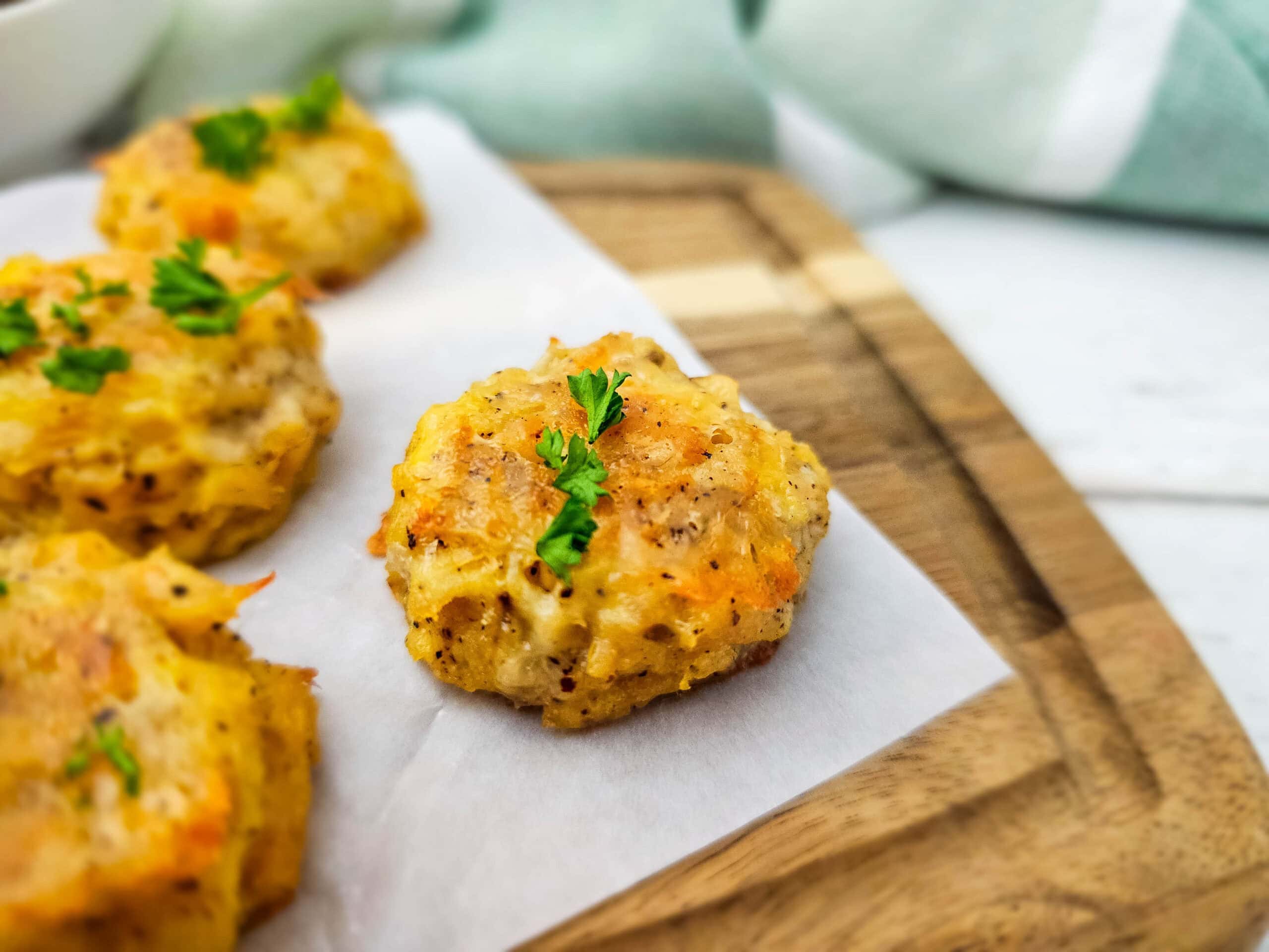Close-up of a golden-brown low carb chicken nugget topped with fresh parsley, highlighting its crispy edges and tender texture.
