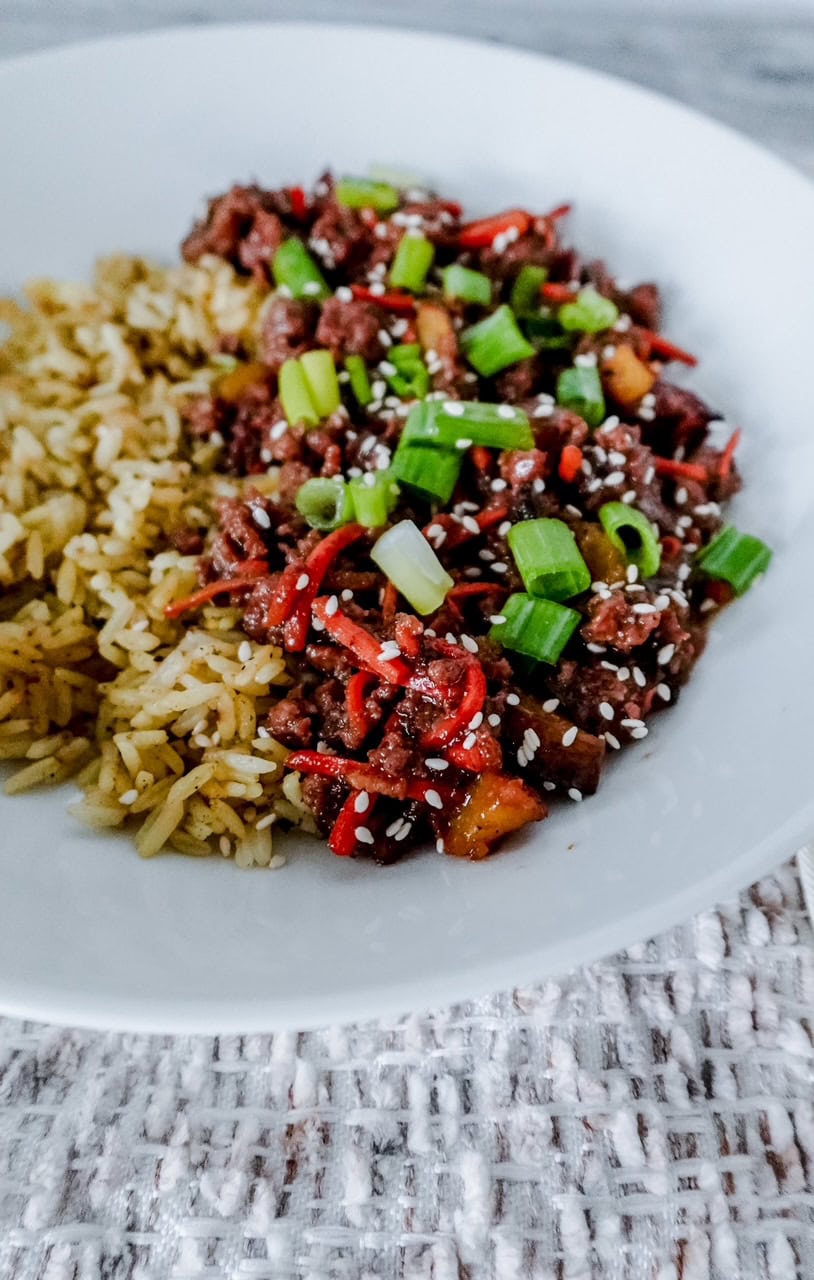 Close up of Korean BBQ beef and rice in a white serving bowl