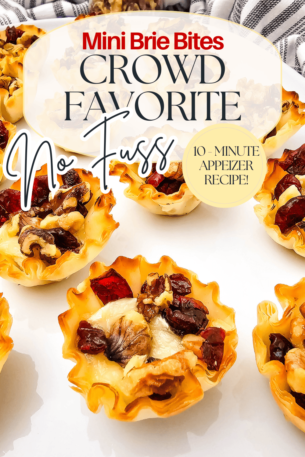 Mini brie bites in crispy cups, topped with walnuts and dried cranberries, arranged on a white surface. Text overlay reads: Mini Brie Bites Crowd Favorite No Fuss, 10-Minute Appetizer Recipe!.