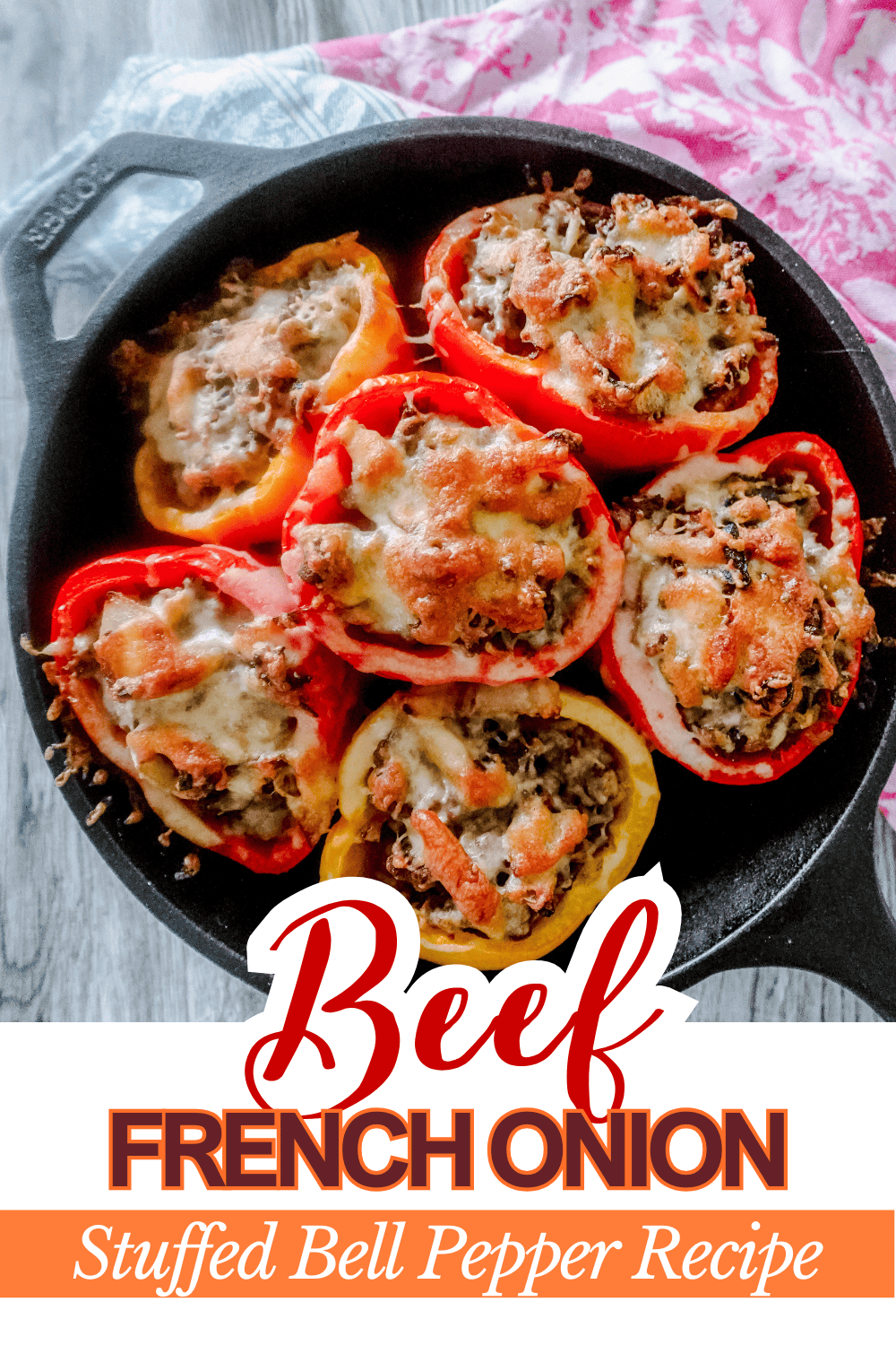 A cast iron skillet filled with six baked bell peppers stuffed with beef, onions, and melted cheese. Text overlay reads: Beef French Onion Stuffed Bell Pepper Recipe. A pink patterned cloth is partially visible.