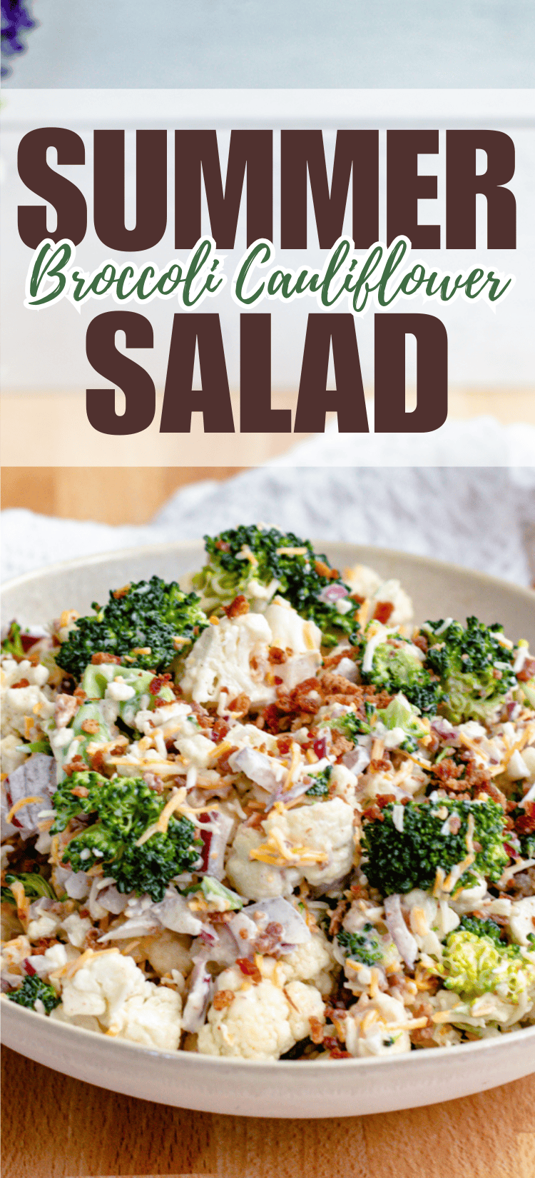 A wooden bowl filled with a fresh salad made of broccoli, cauliflower, red onions, bacon bits, and shredded cheese. Text above reads Summer Broccoli Cauliflower Salad.