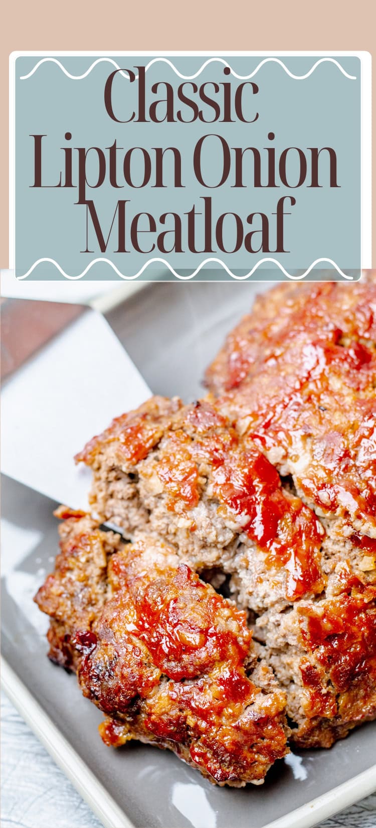 A rectangular meatloaf topped with a shiny layer of ketchup is being sliced and served on a gray plate. The image is labeled Classic Lipton Onion Meatloaf.