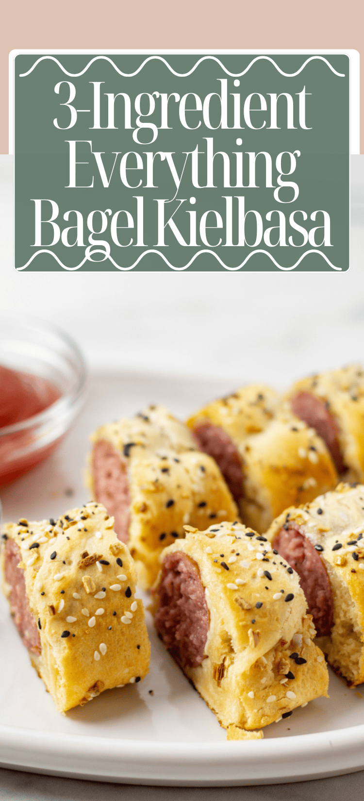 Plated slices of kielbasa wrapped in golden pastry, topped with everything bagel seasoning, with a bowl of dipping sauce in the background and text reading “3-Ingredient Everything Bagel Kielbasa.”.