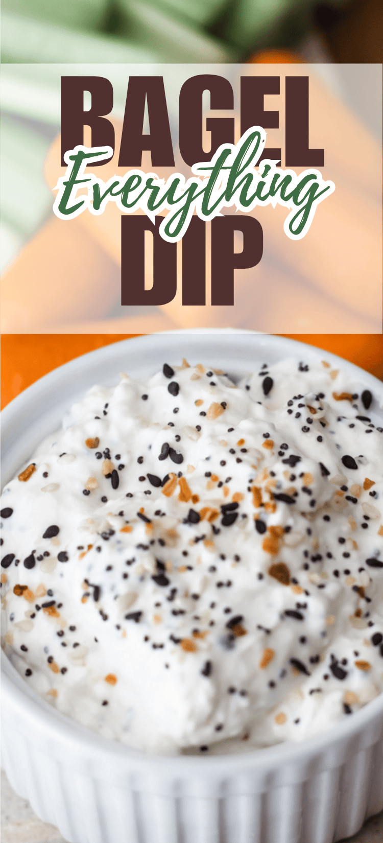 A bowl of creamy bagel dip topped with everything bagel seasoning sits in the foreground. The text above reads Bagel Everything Dip with blurred vegetables in the background.