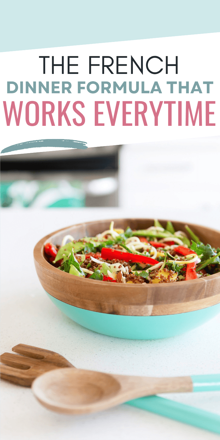 A wooden bowl with a turquoise base filled with a colorful salad sits on a white countertop, beside a matching wooden salad server. Text above reads: The French Dinner Formula That Works Every Time.