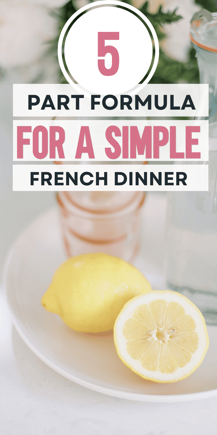 A sliced lemon and a glass bottle on a white plate with text overlay: 5 Part Formula for a Simple French Dinner in bold fonts. Blurred flowers and glasses in the background.